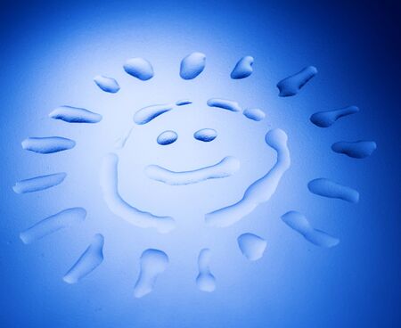 Abstract blue graphic of a sun with a smiling face. Polar or cold feeling.の写真素材