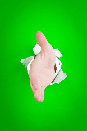 A man's hand extended to shake with a green background. の写真素材