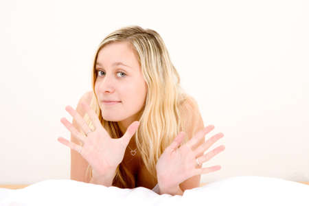 A portrait of a blond teenage girl gesturing with her hands open.の写真素材