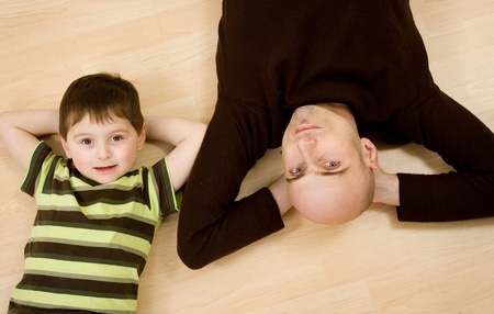 A father and son lying down on the floor. の写真素材