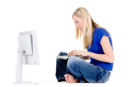 Woman sitting on the floor working on a computer.の写真素材