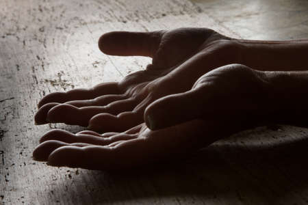 Pair of lined senior persons hands with grainy wood background, black and white image.の写真素材