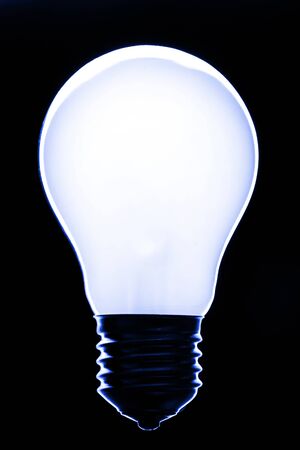 A lit light bulb on blackの写真素材