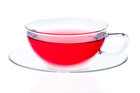 Glass cup and saucer containing red tea, isolated on white background.の写真素材