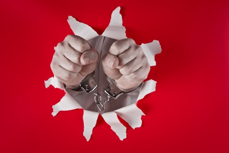 two male fists in shackles on red backgroundの写真素材