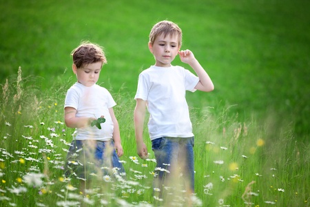 Two young siblings playing in green field.の写真素材