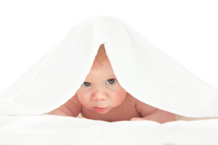 Portrait of a cute little baby boy covered with a blanket on his head. Image isolated on white studio background.の写真素材
