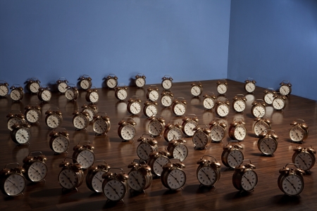 Many alarm clocks on a wooden floor. Art installation.の写真素材