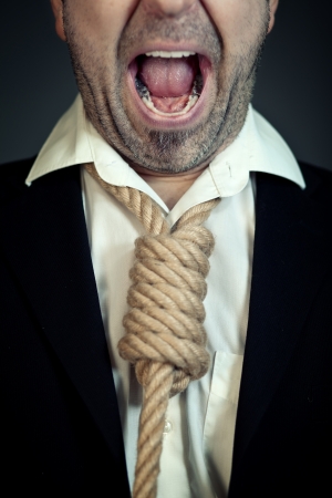 Unshaven businessman with a noose instead of a tie around his neck screaming.の写真素材