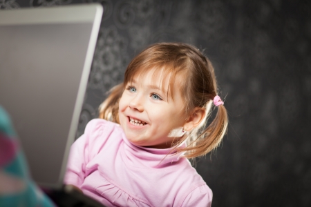 Young girl uses a laptop computer at home.の写真素材
