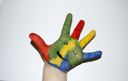 smiley on a painted child's hand on a white backgroundの写真素材