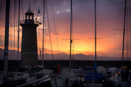 The masts of boats and a lighthouseの写真素材