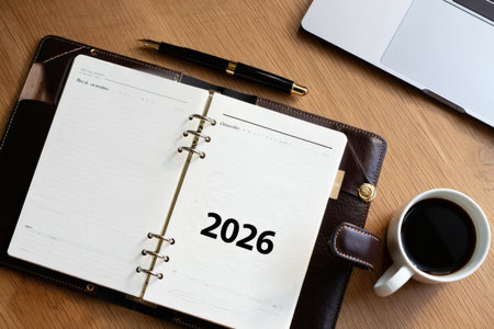 Open 2026 Planner on Wooden Desk with Coffee and Pen, Business Planning Conceptの素材