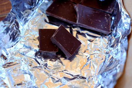 broken chocolate bar, broken background dark gold, wrapper