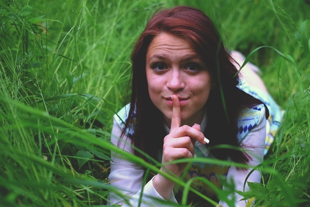 Girl in the grass lying, people spring happyの写真素材