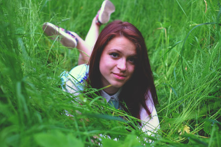 Girl in the grass lying, people spring happyの写真素材