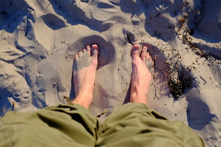 Feet on the sand of the sea beach, water, legs summer seashoreの写真素材