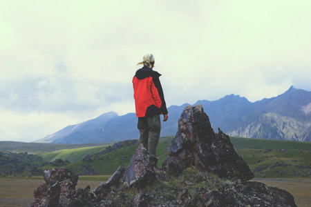 A man on a cliff with views of the mountains, rockの写真素材