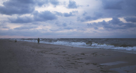 A stormy sea and a man on the shore beach, shore, blueの写真素材