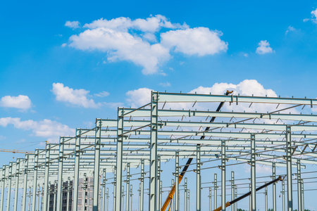 Steel frame structure is under construction, blue sky and white clouds
