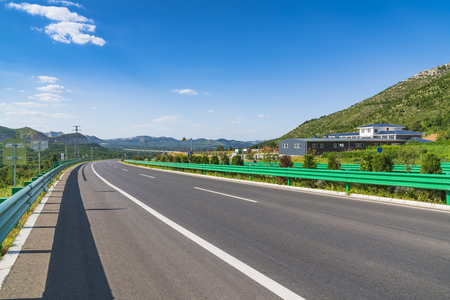 Asphalt road landscape under blue sky and white cloudsのeditorial素材