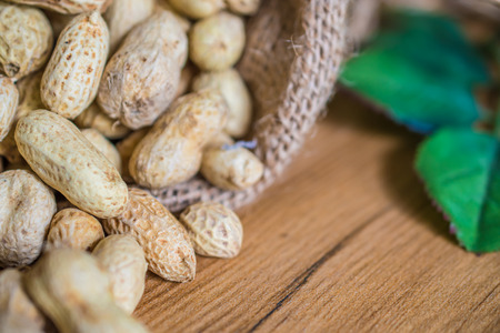 Peanuts in  on sack wood background