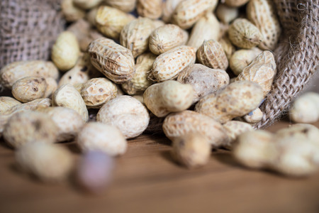 Peanuts in  on sack wood background