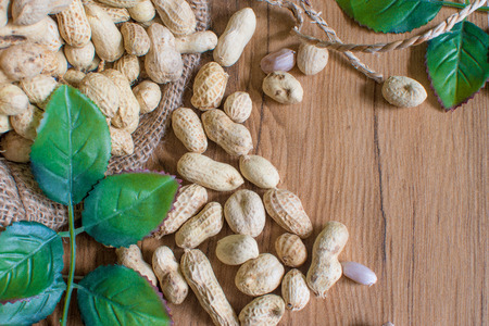 Peanuts in  on sack wood background