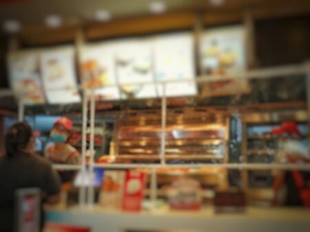 Blur image for clear plastic sheet scene in counter fried chicken shop business Prevents the spread of saliva spray virus infection of sellers waiting for buyers to order food in the close distance.の写真素材