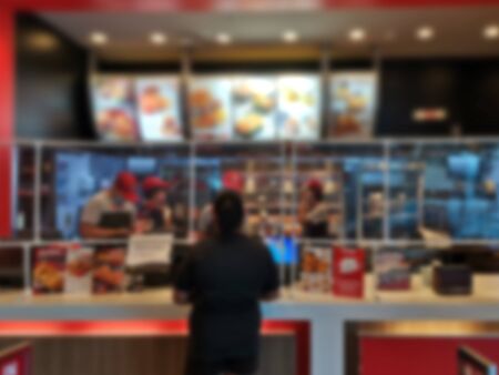 Blur image for clear plastic sheet scene in counter fried chicken shop business Prevents the spread of saliva spray virus infection of sellers waiting for buyers to order food in the close distance.の写真素材
