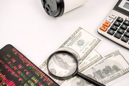 Loss of stock indexes on mobile and calculations for the stock market and the concepts highlighted from losing money on white background.の写真素材