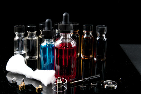 Vaporizer smoke with juice bottles, screwdriver and cotton wick with toolsの写真素材