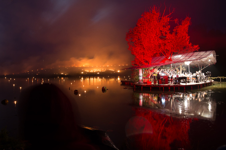 Floating orchestra on a lake with forest fire backgroundの写真素材