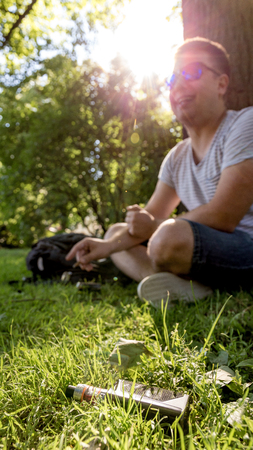 Teen male smoking tobacco cigarillo with vaporizer on foregroundの写真素材