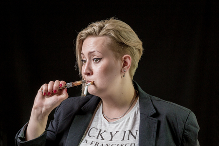 Girl tries to smoke new modern electronic cigaretteの写真素材