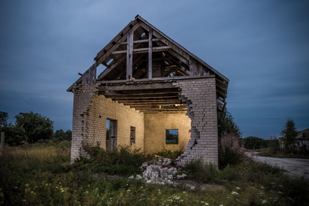 Decayed house with fallen wall and inside lit up by flashの写真素材