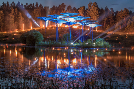 Burning fire in the background with searching lights and reflection from the lakeの写真素材