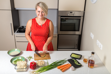 Girl smiling and cutting asparagusの写真素材