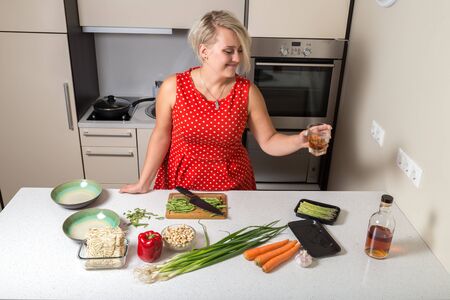Girl holding whiskey glass in one hand and observing it while smilingの写真素材