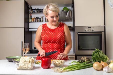 Tortoise eating salad while young girl looks at him and cuts carrotの写真素材