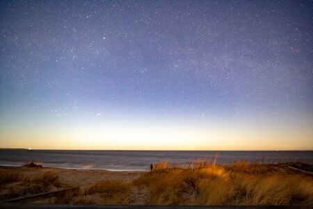 Milky way over sea at night at beachの写真素材