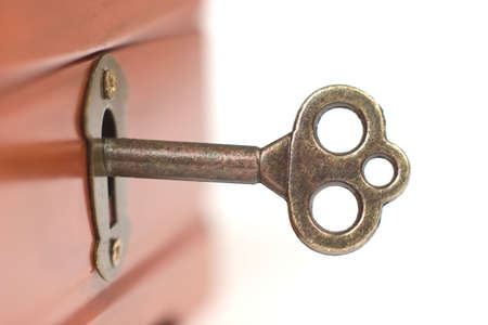 Key in the lock, close-up shot on white backgroundの写真素材