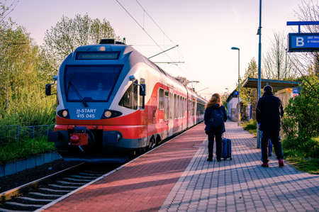 VELENCE, HUNGARY - APRIL 25, 2021: View on the passengers waiting to the Hungarian State Railways train arriving to the station of Agard, Hungary.のeditorial素材