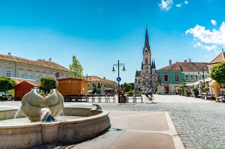 KOSZEG, HUNGARY - AUGUST 14, 2021: View on the Sacred Heart Church or Koszegi Jesus Heart Plebania Church and the people on the Main Squre or Photo on a sunny, cloudy summer day.のeditorial素材