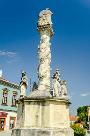 KOSZEG, HUNGARY - AUGUST 14, 2021: Plague column Holy Trinity statue in front of the Sacred heart church in Koszeg on a sunny day.のeditorial素材