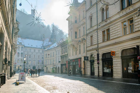 LJUBLJANA, SLOVENIA - JANUARY 15, 2022: View of the people walking on the Stritarjeva street with the Ljubljana Castle in the backgroundのeditorial素材