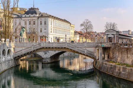 LJUBLJANA, SLOVENIA - FEBRUARY 15, 2022: Cityscape view on Ljubljanica river canal in Ljubljana old town with bridges and historic architecture in Sloveniaのeditorial素材