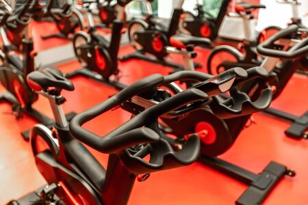 Stationary Spinning bicycles. Indoor cycling for lifestyle design. Fitness background. Healthy lifestyle background. Spinning class with empty bikes. Sport background. Sport, recreation, lifestyle. Fitness workout.の写真素材