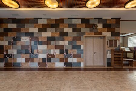 Beautiful, empty naturally lit yoga studio. Yoga room on beige background. Gym equipment. Empty...