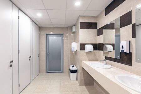 Mens room with white porcelain urinals in line. Comfort male toilet urinal concept. Background...